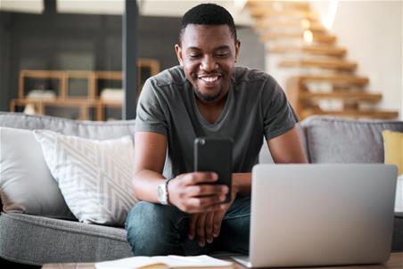 Happy person doing their budget on a laptop